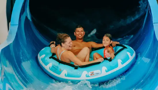 A family on a waterslide in an indoor waterpark